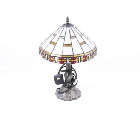 A Tiffany style table lamp. Having a metal finial top, tapered leaded glass shade mounted on a metal reeded column. H35cm