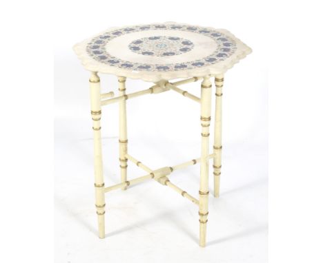 A stone table top on a stand. The shaped top inlaid with mother of pearl and coloured stone to create a floral pattern. The w