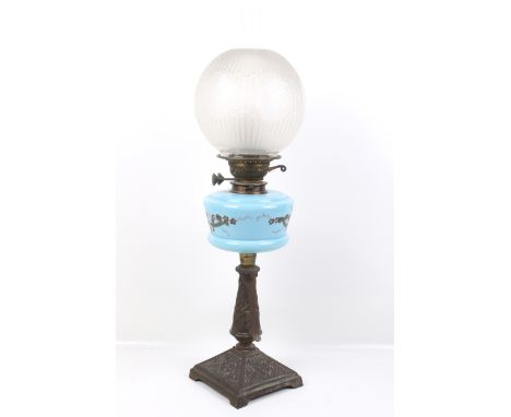 A Victorian oil lamp. With a coloured glass and enamel reservoir, metal base and an etched glass shade. H67cm