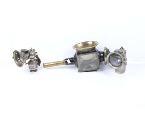 An antique carriage lamp with two bicycle lamps. Including black painted metal candle lit carriage lamp and Lucas carbide bic