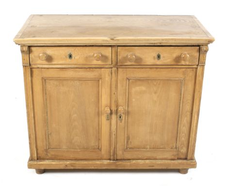 A Victorian waxed pine two door cupboard. With two drawers, two doors opening flanked by fluted column decoration, to reveal 