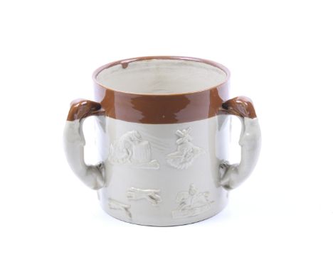 A large Staffordshire stoneware three handled mug. Handles in the form of grey hounds with applied scenes of hunting and drin