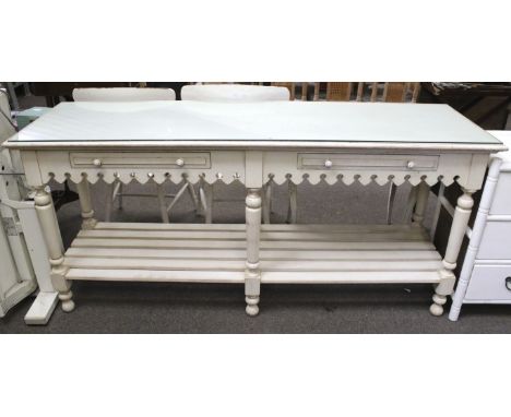 A contemporary painted glass top sideboard. Two drawers beneath with a shaped frieze over a slatted shelf with six turned sup