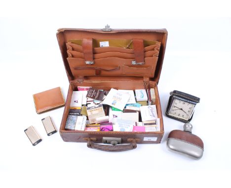 A small vintage leather case and contents. Including a collection of match books, a hip flask and cigarette lighters, etc.