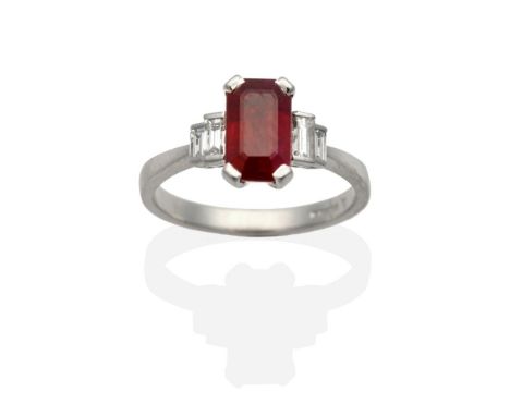 A Platinum Ruby and Diamond Ring, an octagonal cut ruby in a claw setting, spaced each side by two graduated baguette cut dia