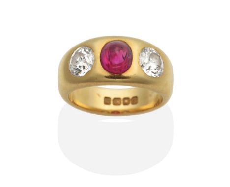 An 18 Carat Gold Ruby and Diamond Three Stone Ring, a high domed oval cabochon ruby between old cut diamonds, inset to a tape