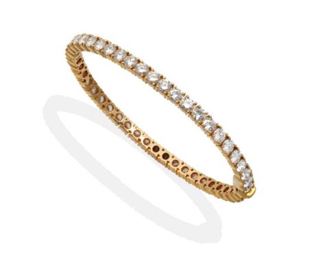 An 18 Carat Gold Diamond Bangle, by Kutchinsky, set in the round with round brilliant cut diamonds in claw settings, total es
