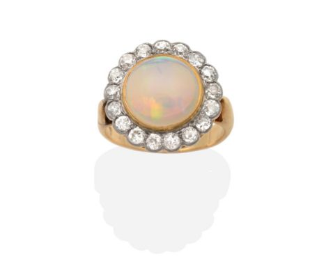 An Opal and Diamond Cluster Ring, a round cabochon opal in a rubbed over setting, within a border of milgrain set old cut dia