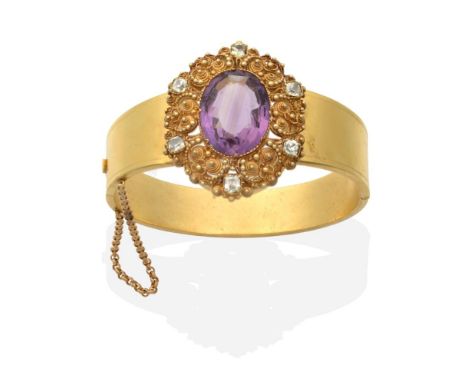 An Amethyst and Chrysoberyl Bangle, an oval cut amethyst within a cannetille frame set with six cushion cut chrysoberyl, to a