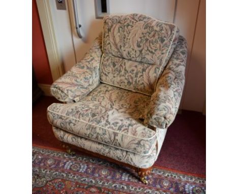 A WILLIAM IV PERIOD MAHOGANY EASY ARMCHAIR, with padded back, cushion seat, raised on reeded turned legs, with brass castors.