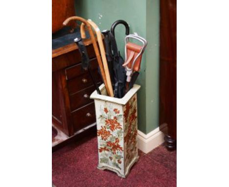 AN ORIENTAL STONEWARE STICK AND UMBRELLA STAND, decorated with flowers; together with an arrangement of handsticks, umbrellas