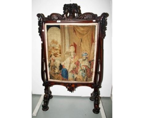 AN ORNATE VICTORIAN CARVED ROSEWOOD AND GRAINED ROSEWOOD CHEVAL FIRE SCREEN,with C-scroll and floral crest above a tapestry p