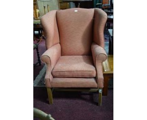A GEORGIAN STYLE MAHOGANY WING ARMCHAIR, with loose cushion, covered in orange fabric. (1) 