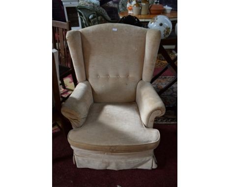 A MODERN WING ARMCHAIR, with loose cushion seat, covered in ivory fabric. (1) 