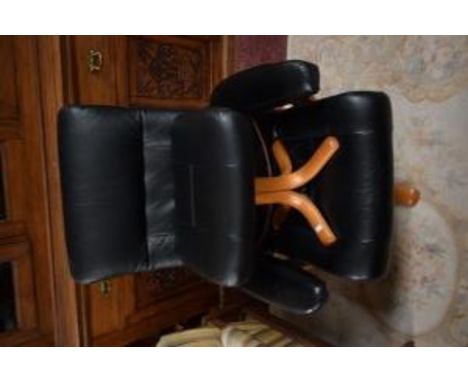 A MODERN RECLINER ARMCHAIR, covered in black hide; together with a matching stool. (2) 