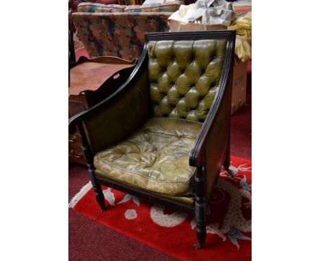 A PAIR OF GEORGE IV STYLE EBONISED LIBRARY ARM CHAIRS, covered in olive green hide, with button back. (2) 