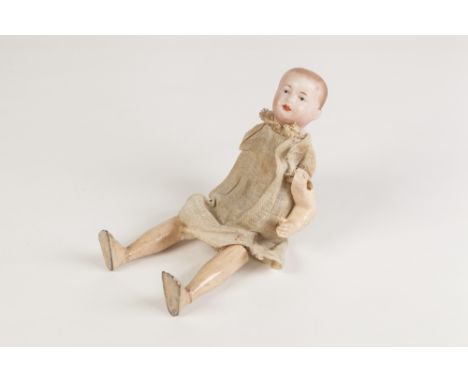 EARLY TWENTIETH CENTURY BISQUE HEADED CRUDE DOLL AUTOMATON, moulded head with painted detail, heavily weighted lower legs on 