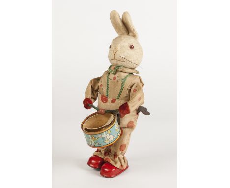 MID TWENTIETH CENTURY TINPLATE AND FELT FABRIC CLOCKWORK DRUMMING RABBIT, depicted standing an playing a snare drum and with 