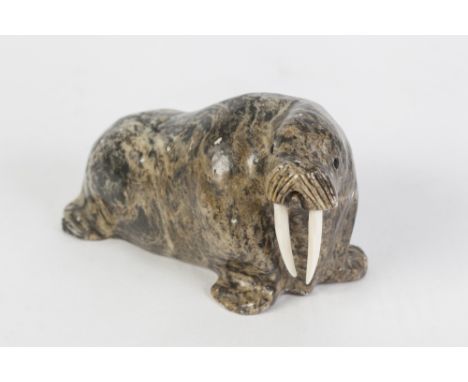 AN INUIT CARVED STONE MODEL OF A WALRUS, with walrus ivory tusks, signed 'Made in Alaska by Larry Eata' and titled 'Hammer', 