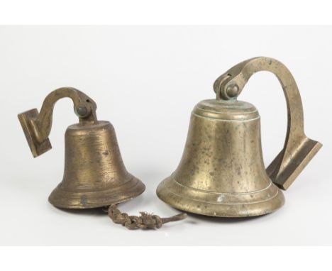 HEAVY BRASS BULKHEAD TYPE BELL pivoting on a scroll shaped wall bracket, 8" (20.3cm) diameter and a smaller ditto, 6" (15.2cm