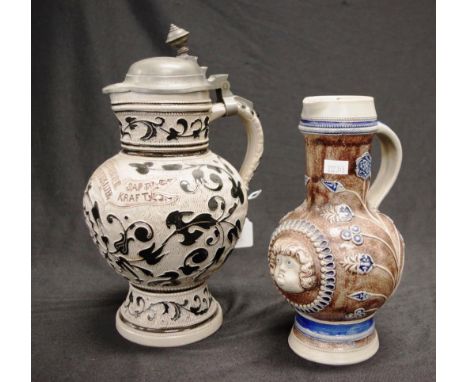 Two various German 'Motto Ware' ceramic jugs including: master stein form, with pewter metal lid, and imprinted German langua