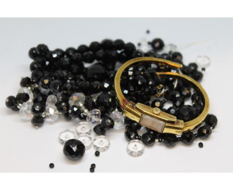 A mixed lot comprising jet, paste and a gold plated bangle watch.  