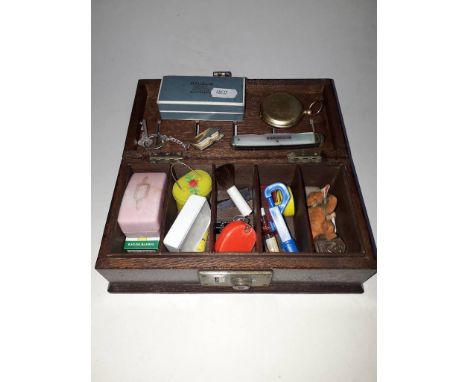A vintage cash box containing bric a brac including compass, vintage razor and blades, mother of pearl handled penknife etc