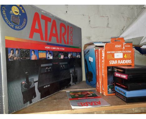 Vintage Atari 2600 video computer system in box with collection of games to include Star Raiders, Super Breakout, King Kong, 