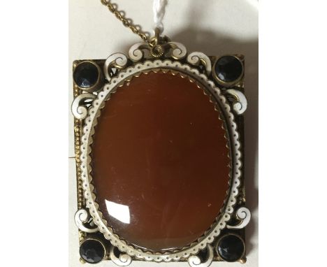 AN EARLY 20TH CENTURY RECTANGULAR BROOCH, THE CORNERS SET WITH BLACK STONES, THE ENAMEL FRAME WITH OVAL CARNELAIN 