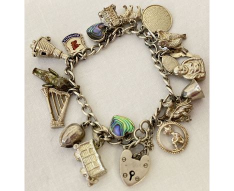 A vintage silver charm bracelet with 17 silver and white metal charms, complete with safety chain.  Charms include WWI Fumsup