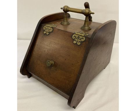 A vintage mahogany coal box complete with coal scoop and liner.  Decorative brass hinges carry handle and lid handle.  Approx