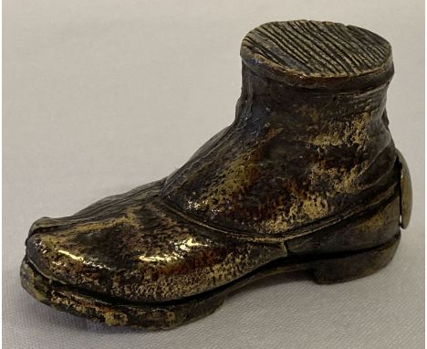 A vintage brass vesta case in the shape of a boot. With hinged opening door on heal of boot.   Approx. 5cm long.
