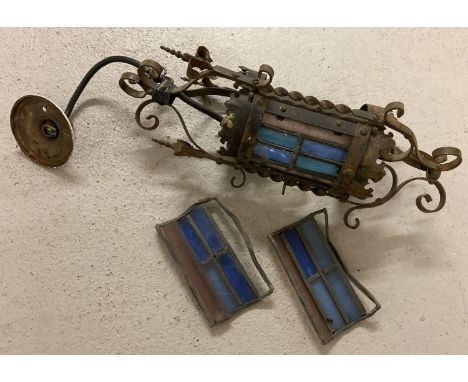 A vintage porch hanging light with coloured glass leaded panels, restoration project.  Ornate scroll work to metal frame of l