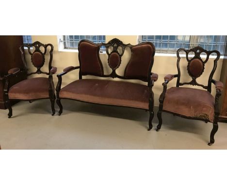 A Victorian 2 seater wooden framed Parlour suite; settee with 2 matching arm chairs.  With carved detail to seat backs, dark 