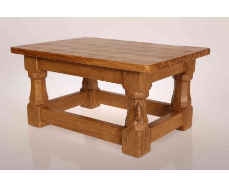 ROBERT THOMPSON OF KILBURN: A MOUSEMAN OAK FOOTSTOOL, with rectangular tiger oak top, raised on short faceted legs terminatin