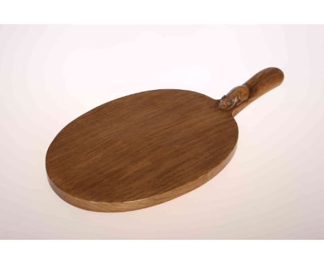 ROBERT THOMPSON OF KILBURN: A MOUSEMAN OAK CHEESEBOARD, of typical oval shape with carved mouse signature to the handle. 41cm