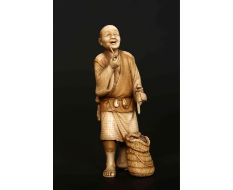 A FINE JAPANESE MEIJI PERIOD IVORY OKIMONO, the one piece carved as an old man smoking a pipe, a basket at his feet, holding 
