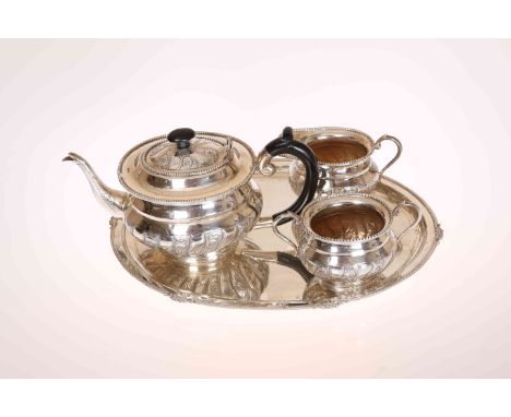 AN INDIAN WHITE METAL TEA SERVICE, comprising teapot, cream jug, sugar bowl and associated oval tray, each stamped SILVER. Gr