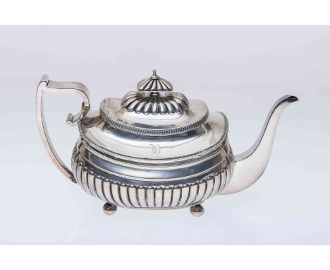 A GEORGE III SILVER TEAPOT, London 1810, with gadrooned edges and partially reeded body, raised on ball feet. 18.5oz, 28cm (h