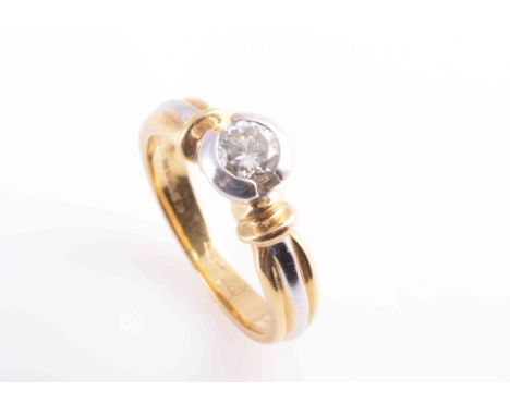 A DIAMOND RING, the single brilliant cut diamond collet set in a raised moulded mount between moulded detail shoulders on a t