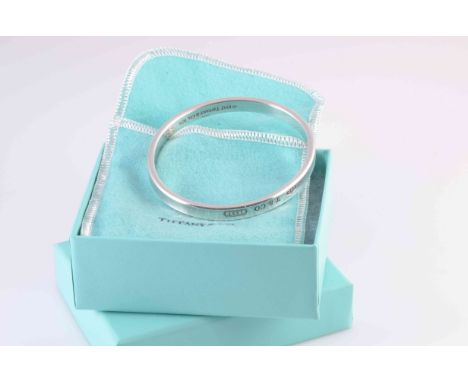 A SILVER BANGLE BY TIFFANY & CO, of simple  moulded detail form. Stamped 925. Makers mark 1997 Tiffany & Co. Weight approxima