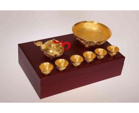 A THAI GILT METAL TEA SERVICE, comprising teapot, bowl and six tea bowls, stamped 9999, in a fitted box. Gross 38.9oz