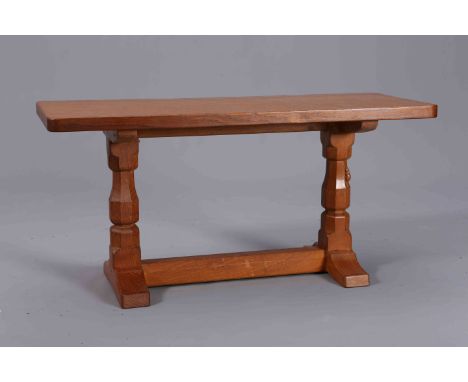 ROBERT THOMPSON OF KILBURN: A MOUSEMAN OAK COFFEE TABLE, of rectangular trestle form, adzed top, faceted baluster legs and ca