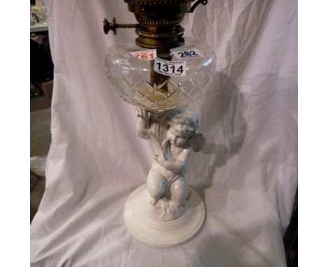 Victorian table oil lamp, the base in the form of a cherub in white ceramic holding cut crystal oil chamber and Duplex burner