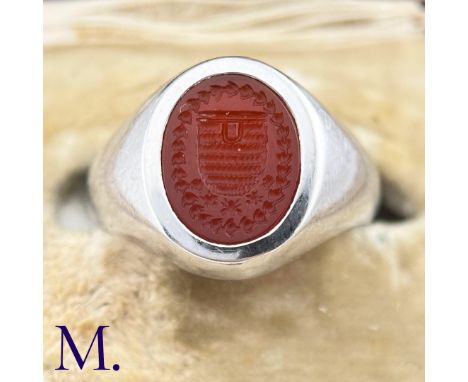 A Platinum and Carnelian Signet RingThe platinum ring is set with a carved oval-shaped carnelian depicting a coat of arms.Wei