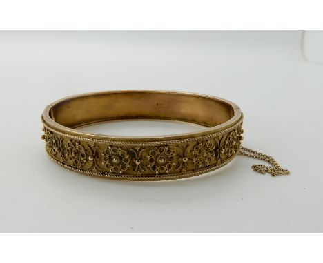 a 9ct gold Etruscan revival bangle, inner diameter 6cm, weight 14.2gms Condition Report: Tongue is missing from the clasp, ot