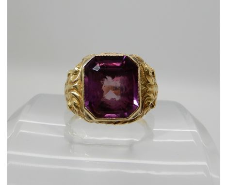 A bright yellow metal gents ring set with a faux amethyst, size U1/2, weight 11.5gms Condition Report: Available upon request