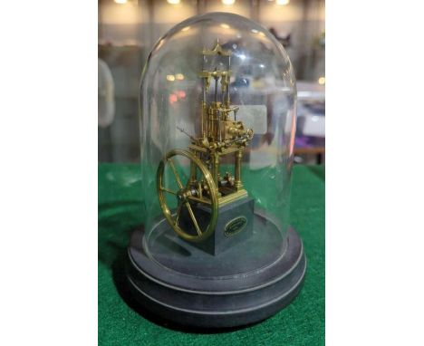 A small brass working model of a stationery engine by Anthony Tyrer, Hastings, mounted on slate under glass dome, 19cms high