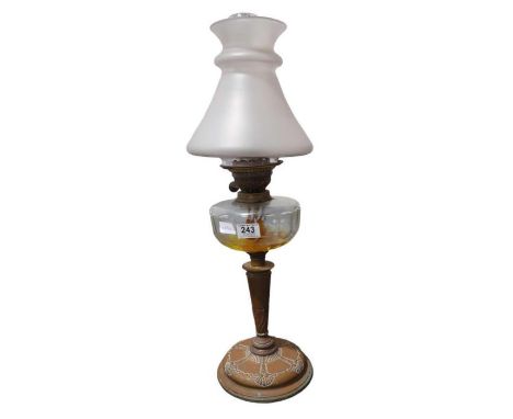 A late Victorian oil lamp having conical shaped frosted glass shade, faceted clear glass reservoir, embossed copper base, 63c