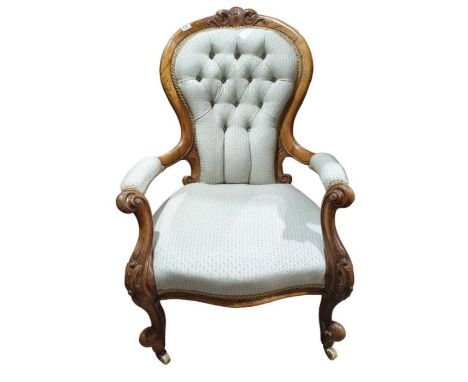 A Victorian button back open arm chair with moulded foliate arms and original casters (re - upholstered)